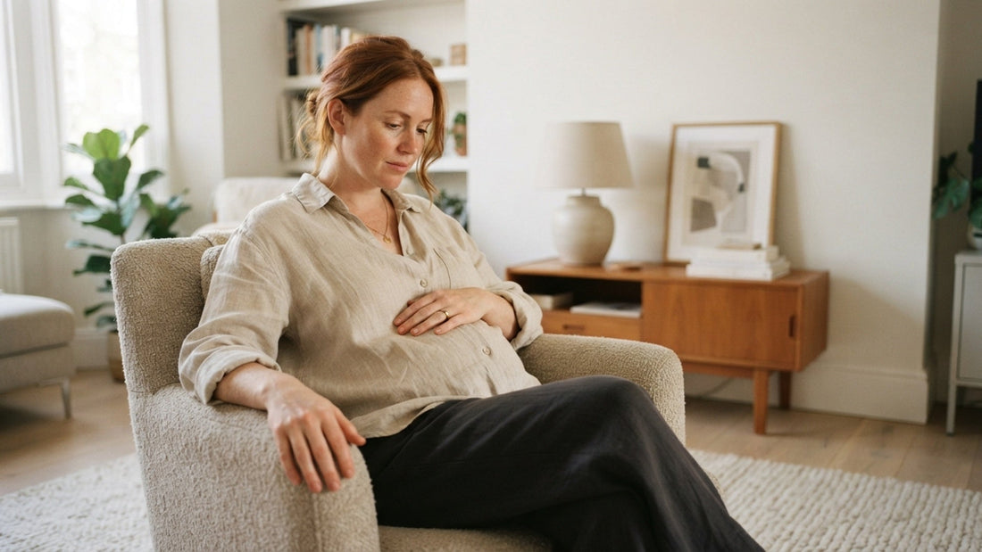 Woman mid 30s visibly pregnant at home